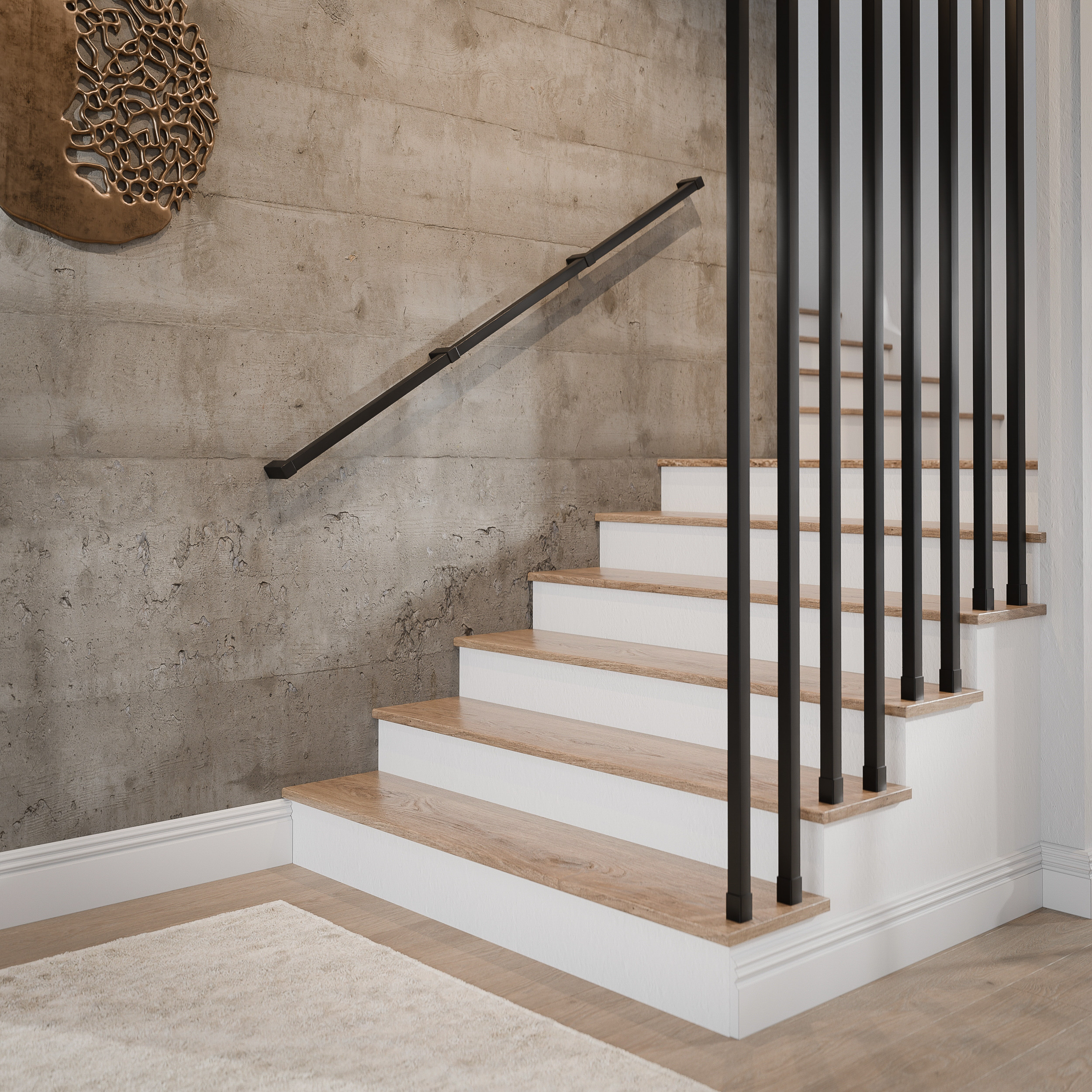 Poręcze ścienne. Czarna poręcz ścienna Faro przy schodach z balustradą. Materiał producenta Artest.